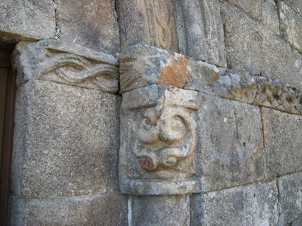 Capitel de piedra con tallos enroscados en la portada occidental