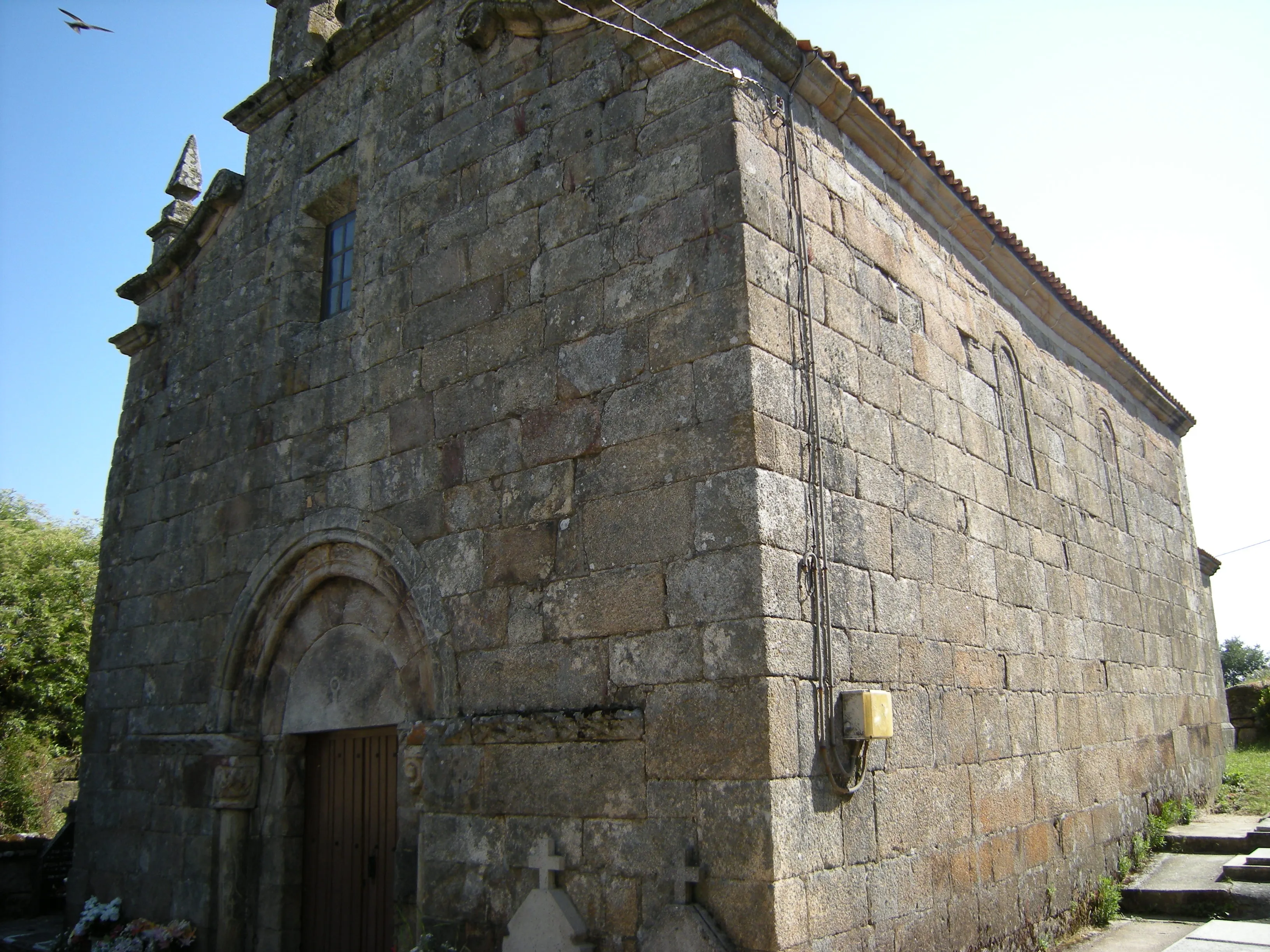 Fachada de piedra de la iglesia de San Cibrao de Nocedo, con portada románica y espadaña