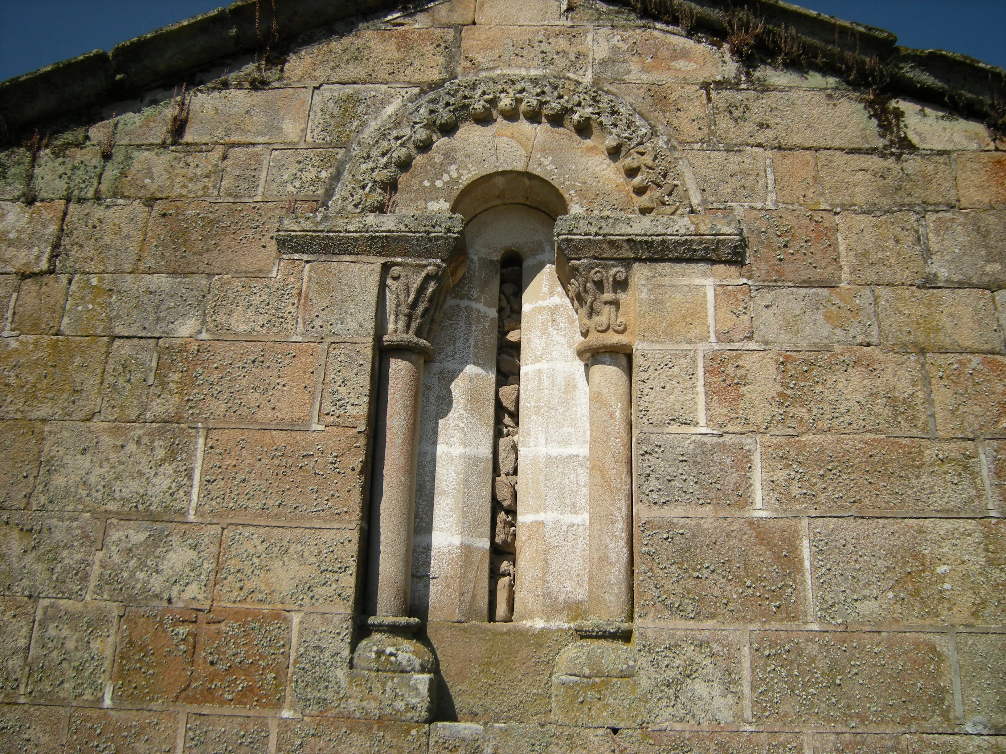 Ventana románica cegada en el muro del ábside